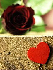 Image showing Red rose and red heart on a wooden table.