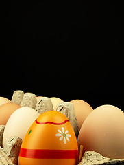 Image showing Colorful Easter egg in the company of ordinary eggs.