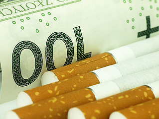 Image showing Cigarettes and money. Expensive habit.