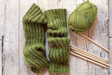 Image showing wool green legwarmers, knitting needles and yarn