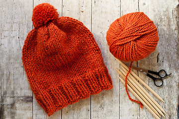 Image showing wool orange hat, knitting needles and yarn