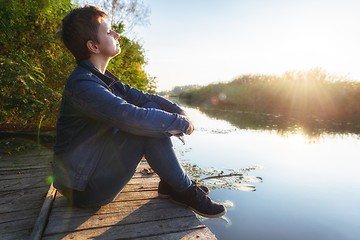 Image showing Woman relaxing on jetty