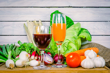 Image showing Vegetables on a wooden table with juice