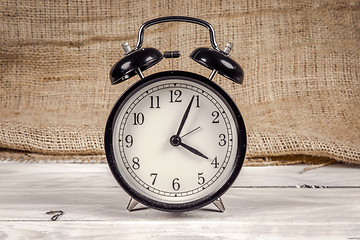 Image showing Classic alarm clock on a wooden table