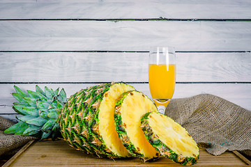 Image showing Pineapple and juice on a wooden board