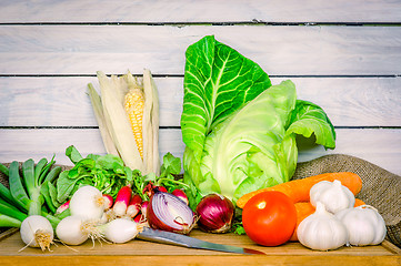 Image showing Vegetables on a wooden table with a knife