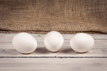 Image showing Three eggs on a wooden table