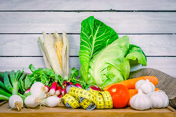 Image showing Vegetables on a wooden table with measure tape