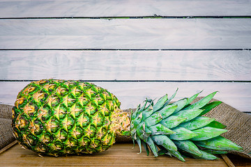 Image showing Pineapple on a wooden table with linen