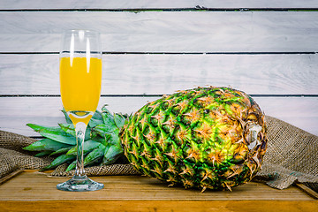 Image showing Pineapple and juice on a wooden table