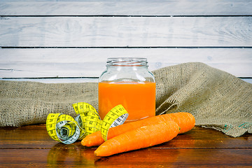 Image showing Carrot juice with measure tape on a table