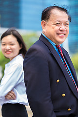 Image showing Young Asian female executive and senior businessman in suit portrait