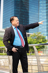 Image showing Senior businessman in suit pointing at a direction