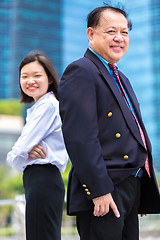 Image showing Young Asian female executive and senior businessman in suit portrait