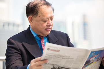 Image showing Senior businessman in suit reading newspaper