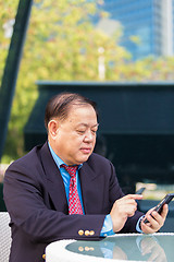 Image showing Senior businessman in suit using smart phone