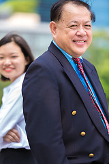 Image showing Young Asian female executive and senior businessman in suit portrait