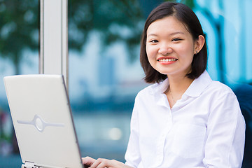 Image showing Young Asian female executive using laptop PC