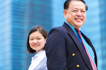 Image showing Young Asian female executive and senior businessman in suit portrait