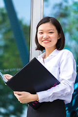 Image showing Young Asian female executive holding file smiling portrait