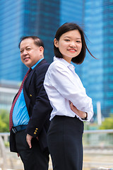 Image showing Young Asian female executive and senior businessman in suit portrait