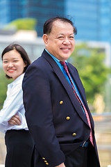 Image showing Young Asian female executive and senior businessman in suit portrait