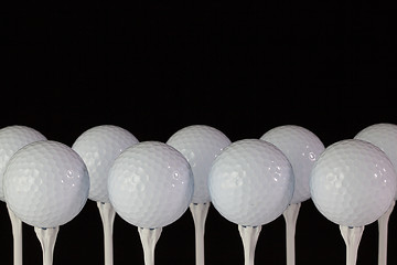 Image showing White golf balls on a white tees