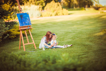 Image showing Mother and little daughter paint together