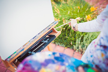 Image showing Hand with paintbrush and easel