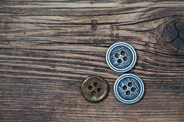 Image showing set of vintage buttons on wooden boards aged antique table. inst