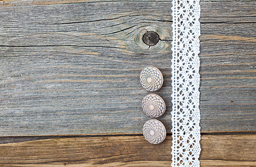 Image showing Three vintage bone buttons and lace tape