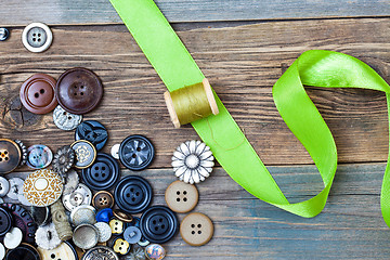 Image showing spool with thread, vintage buttons and green tape