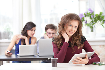 Image showing smiling young girl with tablet in classroom