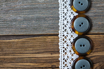 Image showing four vintage buttons and antique lace on ancient boards aged tab