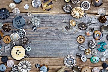 Image showing set of vintage buttons on aged wooden boards