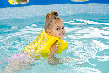 Image showing Girl learning to swim in the pool