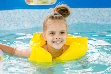 Image showing Cheerful girl swimming in pool swimming vest