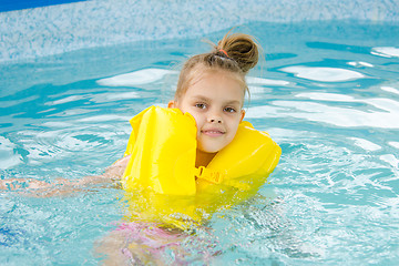 Image showing Girl swimming in the pool in the lifejacket