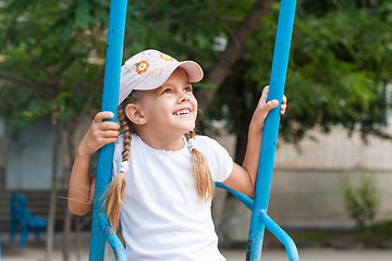 Image showing Happy girl riding on a swing