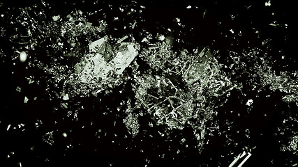 Image showing Pieces of splitted or cracked glass on black