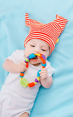 Image showing toddler in a striped hat on a blue blanket