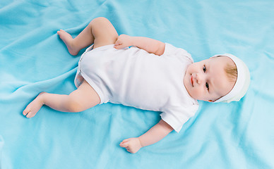 Image showing baby in hat lying on a blue blanket