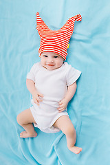 Image showing toddler in a striped hat on a blue blanket