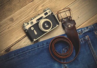 Image showing old blue jeans, vintage leather belt and ancient rangefinder cam