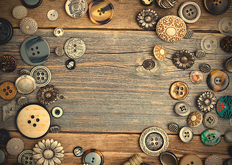 Image showing set of vintage buttons on aged wooden boards