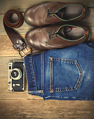 Image showing Still life with blue jeans, brown boots, leather belt and camera
