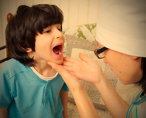 Image showing doctor looks throat of child