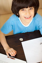 Image showing smiling child doing homework