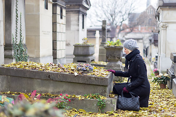 Image showing Solitary woman visiting relatives grave.