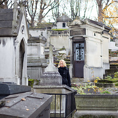 Image showing Solitary woman visiting relatives grave.